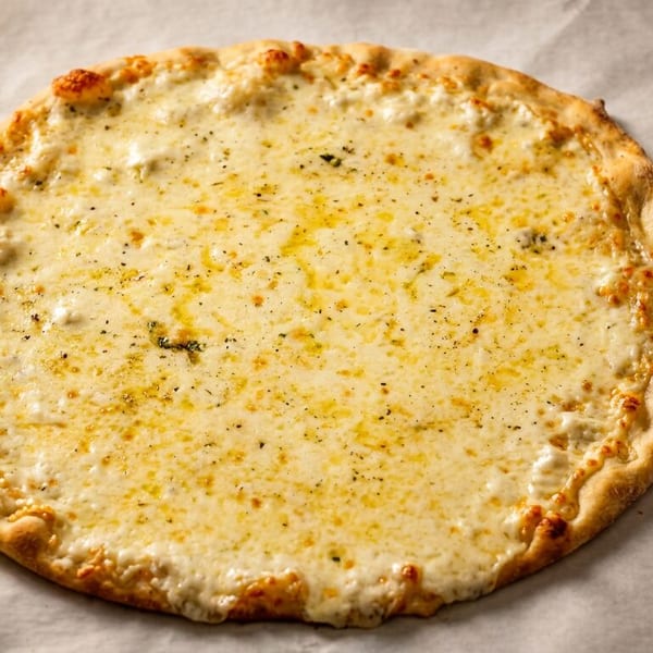 A freshly baked white pizza with melted cheese and herbs on parchment paper.